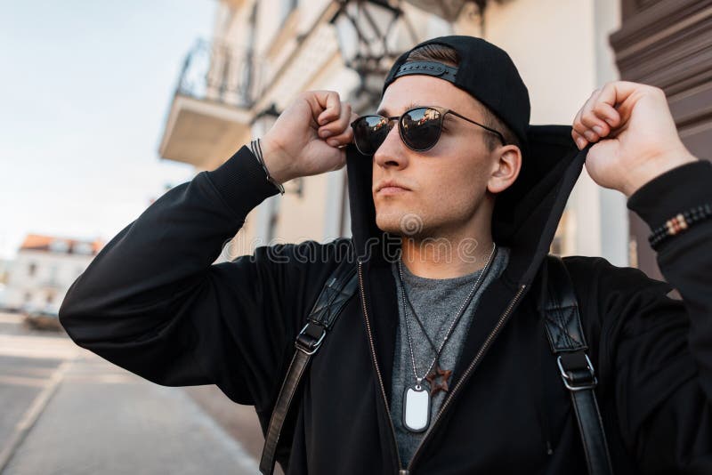 Le Jeune Homme élégant De Hippie Dans Un Pull Molletonné à Capuchon Dans  Une Casquette De Baseball Dans Des Lunettes De Soleil Av Image stock -  Image du capuchon, américain: 150163089