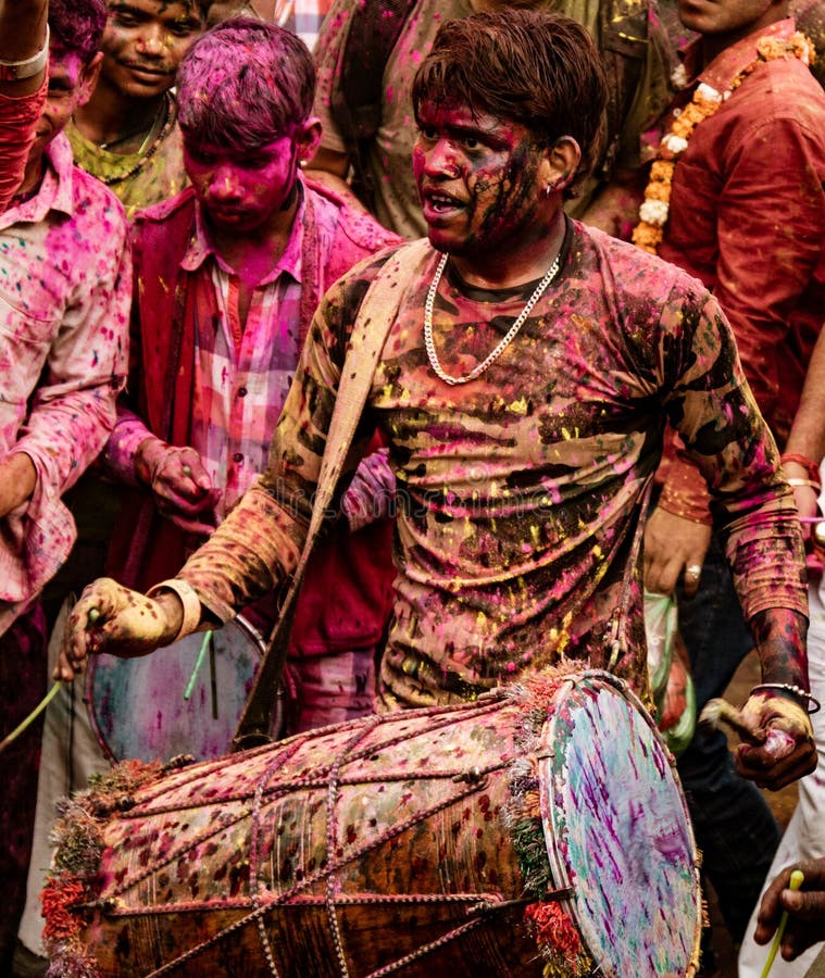 Le jeune homme bat le tambour pour fournir la musique pour le festival de Holi dans l'Inde image stock Le jeune homme bat le tambour pour fournir la musique pour le festival de Holi dans l'Inde image stock