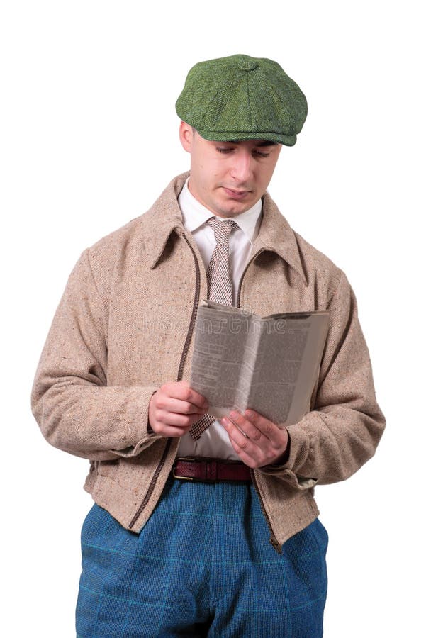 Le jeune homme dans le vintage vêtx avec le chapeau, lisant le journal, les années 1940 images libres de droits Le jeune homme dans le vintage vêtx avec le chapeau, lisant le journal, les années 1940 images libres de droits