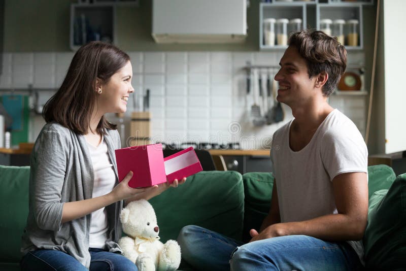 Le jeune homme a donné à la fille aimée un cadeau photos libres de droits Le jeune homme a donné à la fille aimée un cadeau photos libres de droits