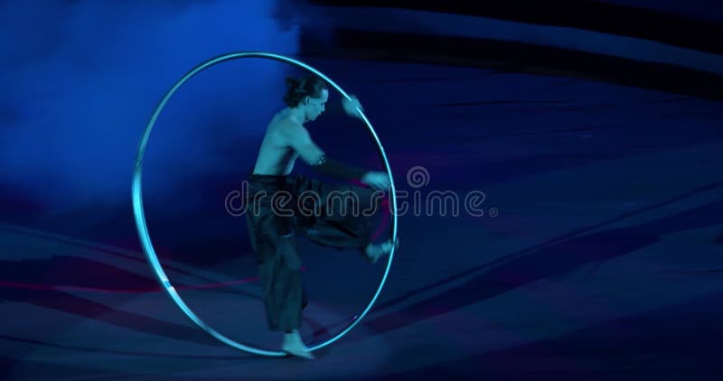 Le jeune homme est rotatif et marchant dans une roue sur la scène d'un cirque 4k banque de vidéos