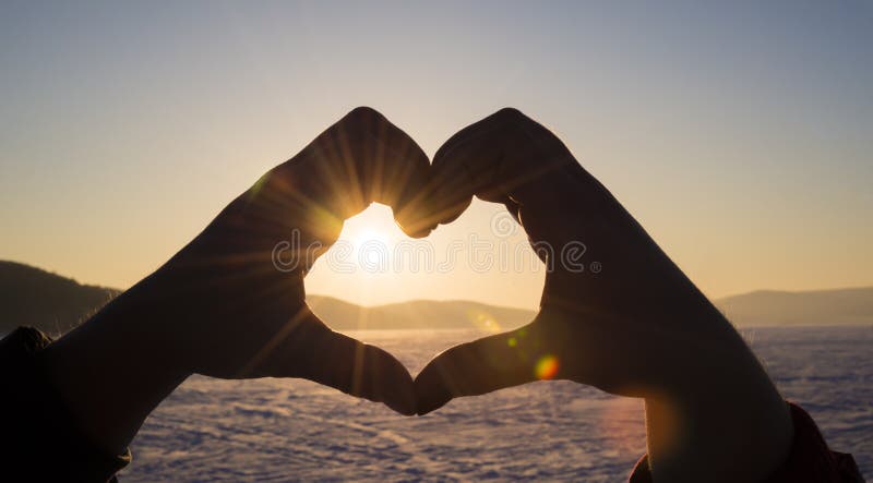 Le jeune homme et la femme faisant un coeur forment avec ses doigts images libres de droits Le jeune homme et la femme faisant un coeur forment avec ses doigts images libres de droits