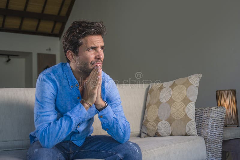 Le jeune homme latin triste attirant et bel reposant à la maison le sentiment fatigué et diminué de divan de sofa a accablé et su image libre de droits Le jeune homme latin triste attirant et bel reposant à la maison le sentiment fatigué et diminué de divan de sofa a accablé et su image libre de droits