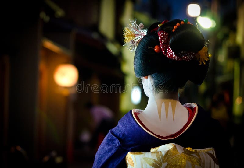 Le jeune maiko marche dans les rues du coin de Gion