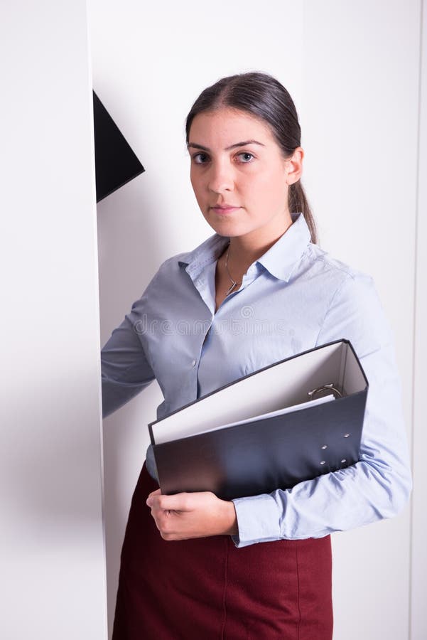 Le jeune professionnel féminin met des reliures dans le coffret images libres de droits Le jeune professionnel féminin met des reliures dans le coffret images libres de droits