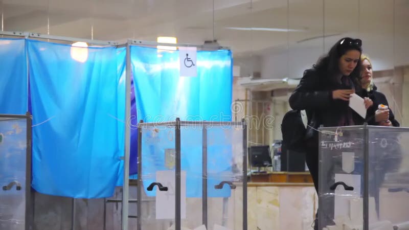 Le jeune électeur féminin met le vote dans l'urne  ?lection de pr?sident de l'Ukraine Observateurs de monito différent de partis