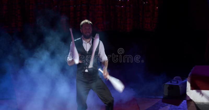 Le jongleur professionnel de sourire exécute sur la scène d'une fumée 4k du cirque clips vidéos