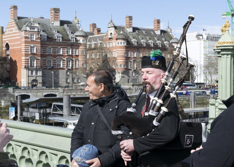 Le joueur de cornemuse exécute la musique sur le pont de Westminster, Londres, unissent image libre de droits Le joueur de cornemuse exécute la musique sur le pont de Westminster, Londres, unissent image libre de droits