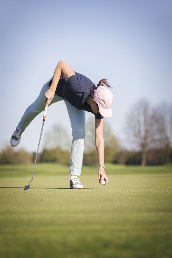 Le joueur de golf de femme prennent la boule photos libres de droits Le joueur de golf de femme prennent la boule photos libres de droits