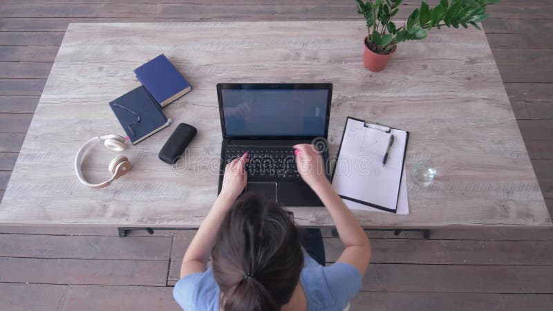 Le jour ouvrable, vue supérieure de texte de dactylographie de jeune femme sur le clavier d'ordinateur portable et écrit des note