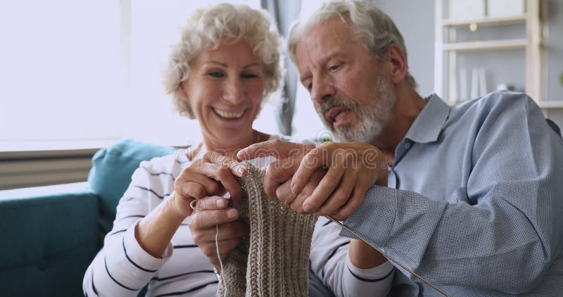 Le juste milieu âgée tricotait les couples mariés l'écharpe de laine grise faite main. banque de vidéos