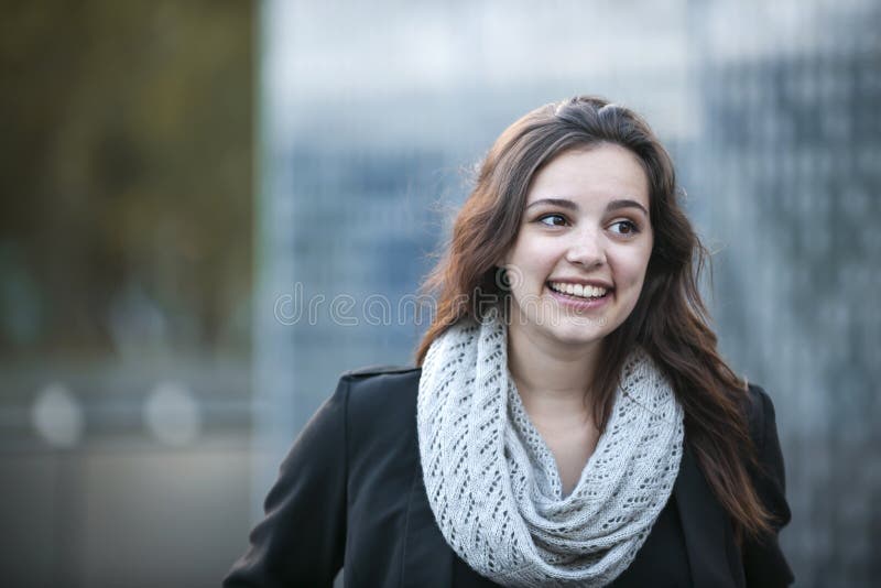 Candid portrait of happy young brunette woman smiling with copy space in urban setting. Candid portrait of happy young brunette woman smiling with copy space in urban setting