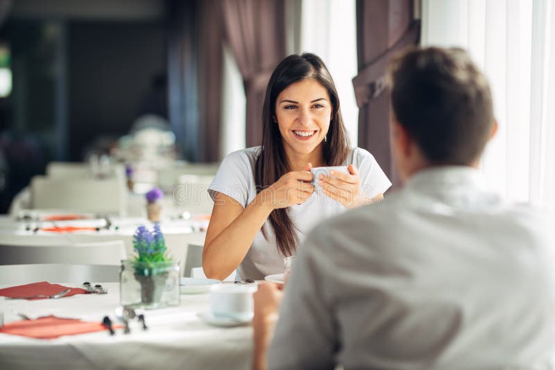 Le kvinnan på ett datum i en restaurang och att ha en konversation över ett mål i hotell Positiva sinnesrörelser, förälskelse, af fotografering för bildbyråer