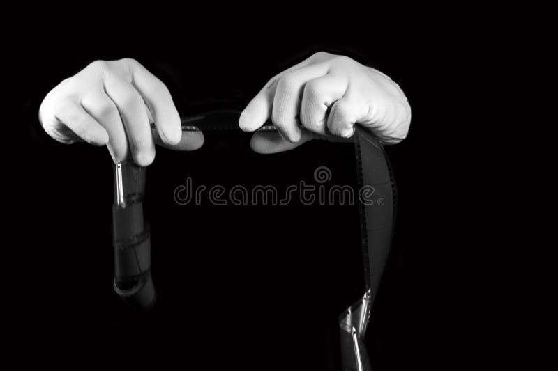 Le laboratoire, mains dans les gants blancs tiennent un film noir et blanc photos stock Le laboratoire, mains dans les gants blancs tiennent un film noir et blanc photos stock