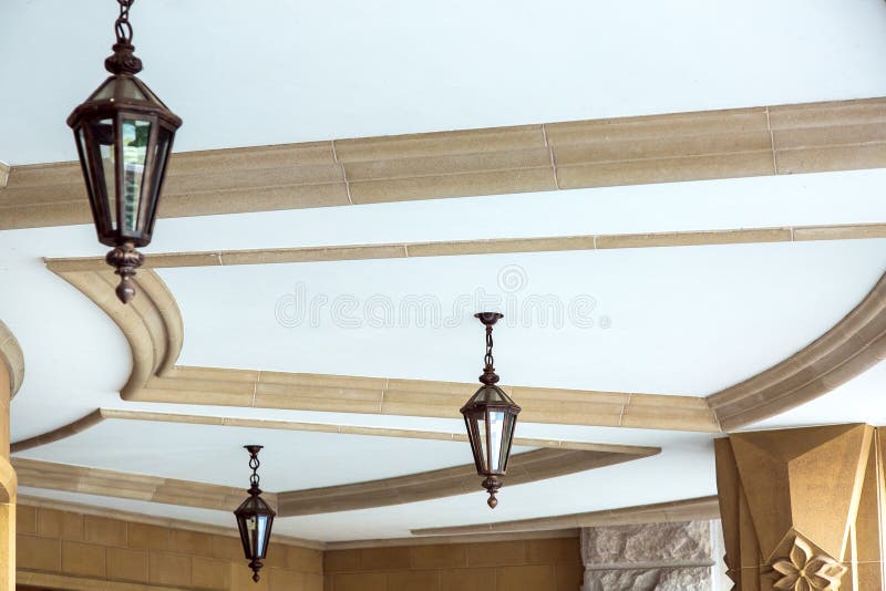 Le lampade forgiate sospese con le inserzioni di vetro pesano sul soffitto immagine stock libera da diritti Le lampade forgiate sospese con le inserzioni di vetro pesano sul soffitto immagine stock libera da diritti