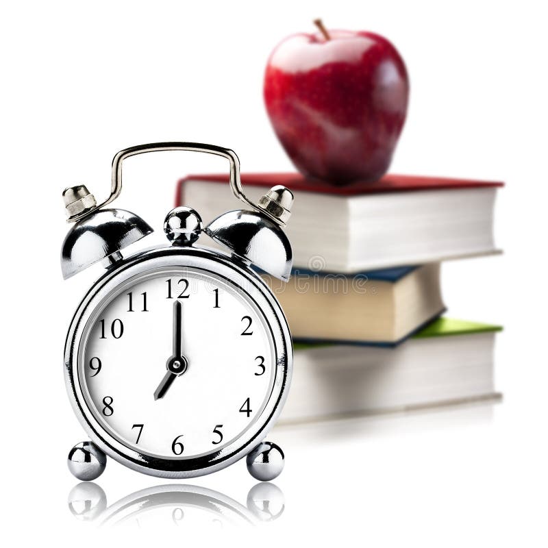 Vintage clock Alarm in foreground and red apple on the top of stack of colored closed books in background on white background. Vintage clock Alarm in foreground and red apple on the top of stack of colored closed books in background on white background