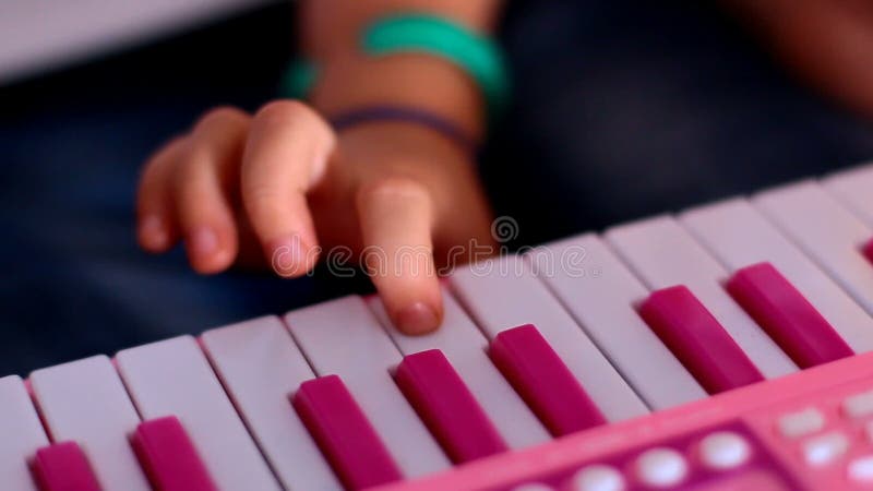 Le macro auriculaire appuie sur des touches sur le piano rose un