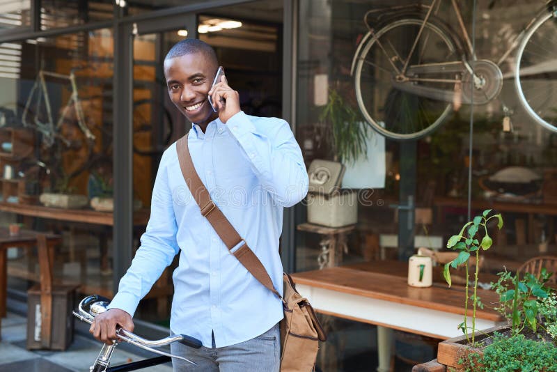 Le mananseende med en cykel som talar på en mobiltelefon royaltyfria foton Le mananseende med en cykel som talar på en mobiltelefon royaltyfria foton