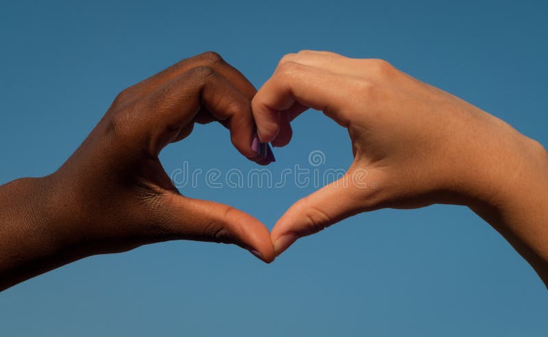 Le mani in bianco e nero nel cuore modellano, concetto interrazziale di amicizia
