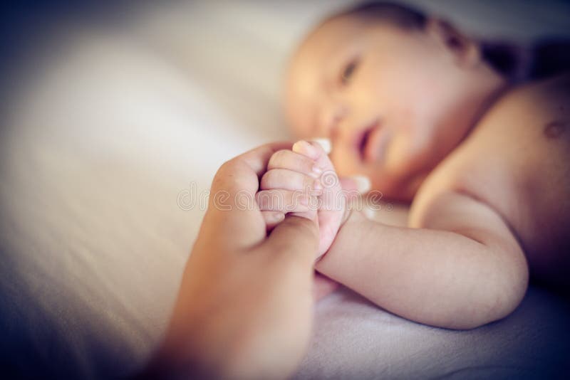 Le mani del ` s della mamma sono sicure immagine stock