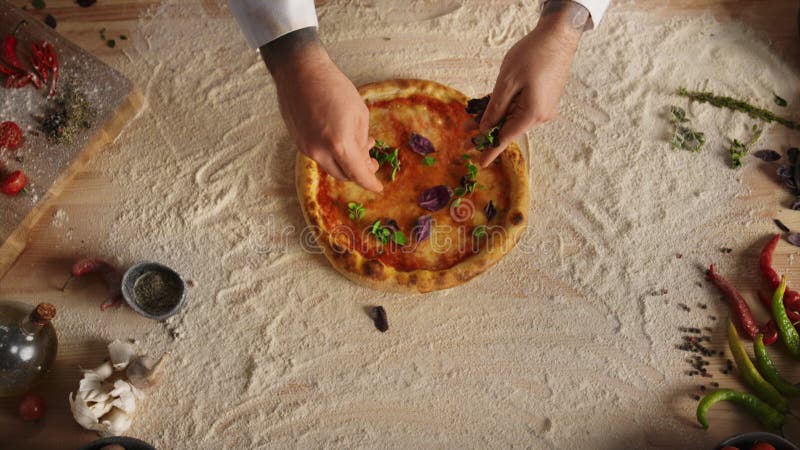 Le mani di chef preparano la ricetta aggiungendo ingredienti sulla pizza italiana al ristorante.