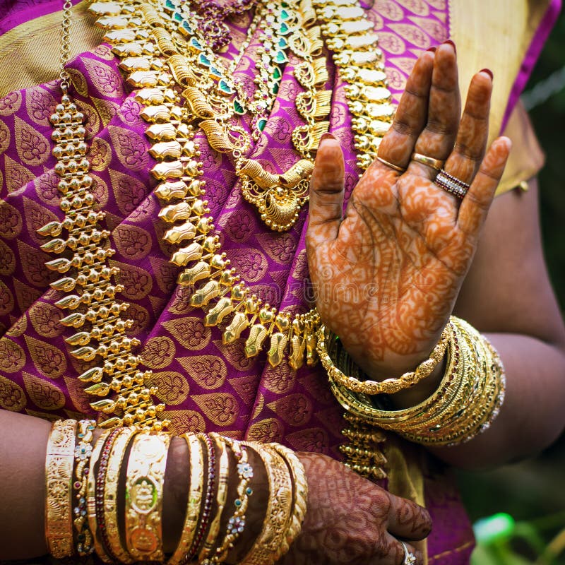 Le mani di una sposa indiana hanno ornato con gioielli