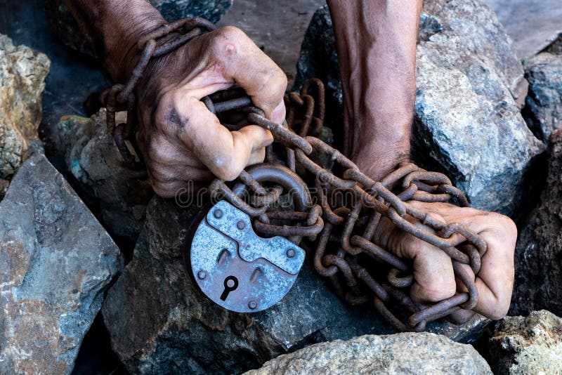 Le mani di uno schiavo nel tentativo di rilasciare Il simbolo del lavoro degli schiavi Mani in catene