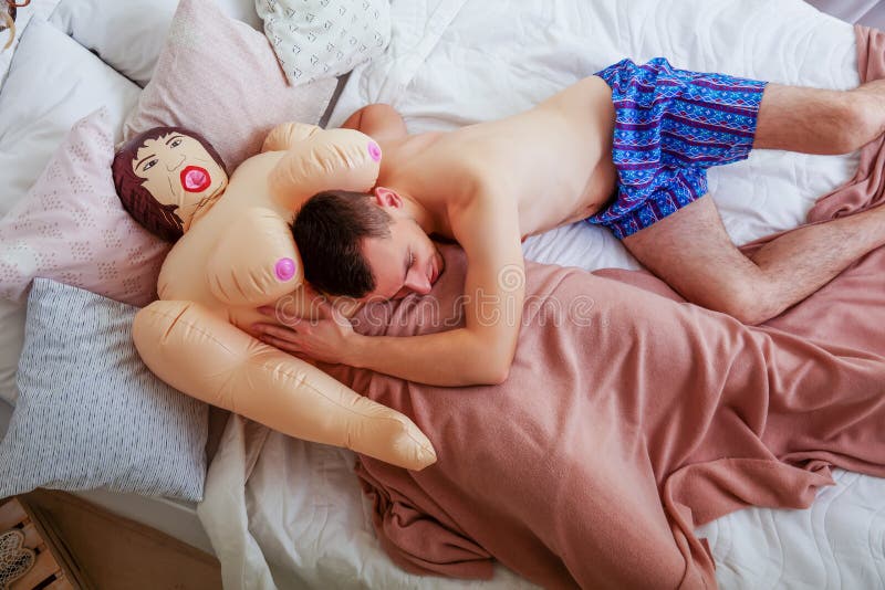 Le mannen som ligger i säng med gummi, könsbestämma dockan arkivfoto Le mannen som ligger i säng med gummi, könsbestämma dockan arkivfoto