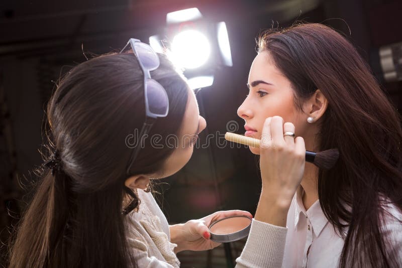 Le maquilleur appliquent le maquillage photographie stock libre de droits Le maquilleur appliquent le maquillage photographie stock libre de droits