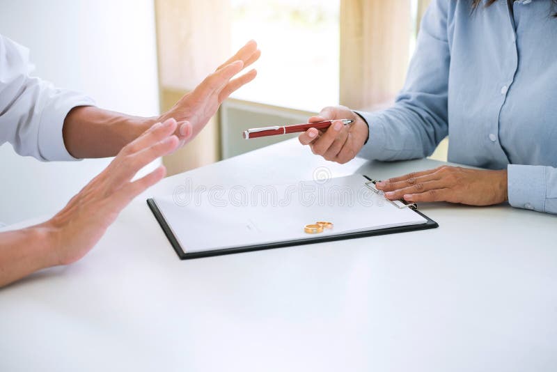 Le mari et l'épouse lisent l'accord de divorce et le stylo de classement à image libre de droits Le mari et l'épouse lisent l'accord de divorce et le stylo de classement à image libre de droits