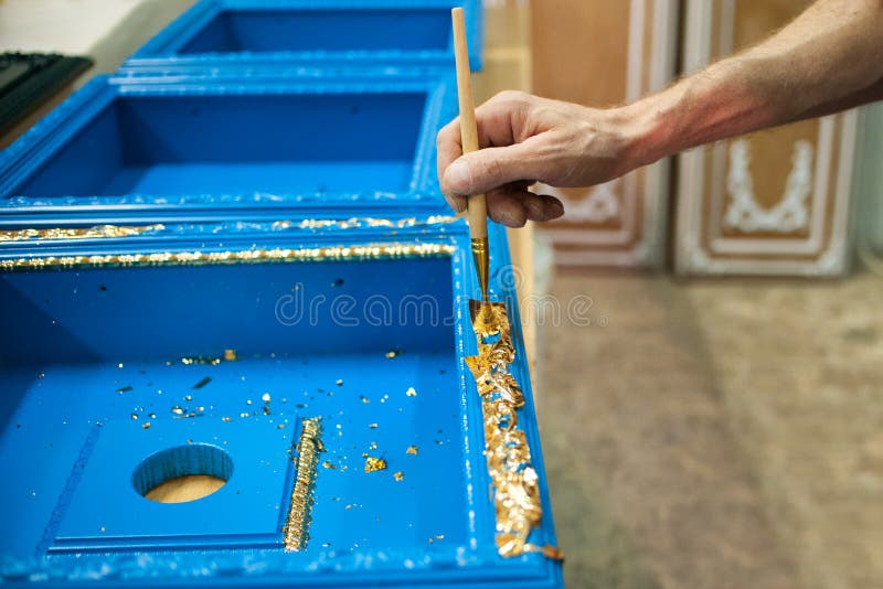 Le maître recouvre la partie en bois de feuille d'or photographie stock