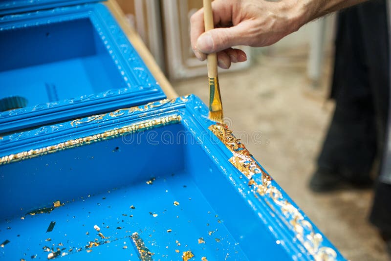 Le maître recouvre la partie en bois de feuille d'or photo stock