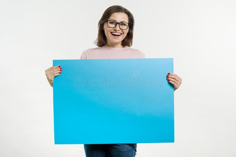 Le milieu de sourire a vieilli la femme avec le panneau d'affichage bleu de feuille photo libre de droits Le milieu de sourire a vieilli la femme avec le panneau d'affichage bleu de feuille photo libre de droits