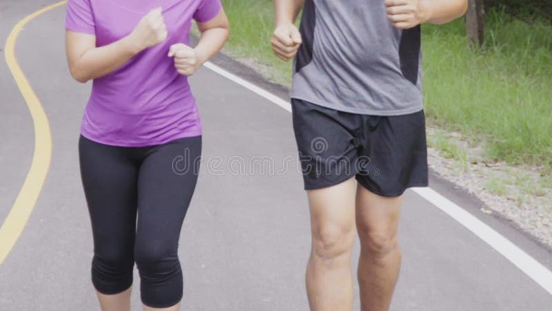 Le milieu haut près de jogging et les couples qui travaillent ensemble au parc banque de vidéos