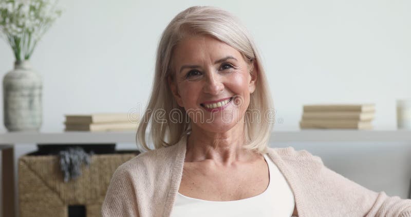 Le milieu plus ancien heureux de la femme à regarder la caméra à la maison banque de vidéos