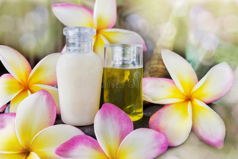 Le mini ensemble de bain moussant et la douche gélifient le liquide avec les fleurs roses photo stock Le mini ensemble de bain moussant et la douche gélifient le liquide avec les fleurs roses photo stock