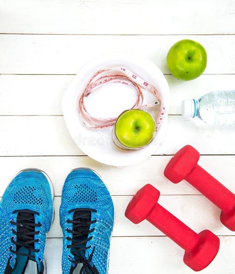 Le mode de vie sain pour des femmes suivent un régime avec l'équipement de sport, les espadrilles, la bande de mesure, les pommes photo stock Le mode de vie sain pour des femmes suivent un régime avec l'équipement de sport, les espadrilles, la bande de mesure, les pommes photo stock