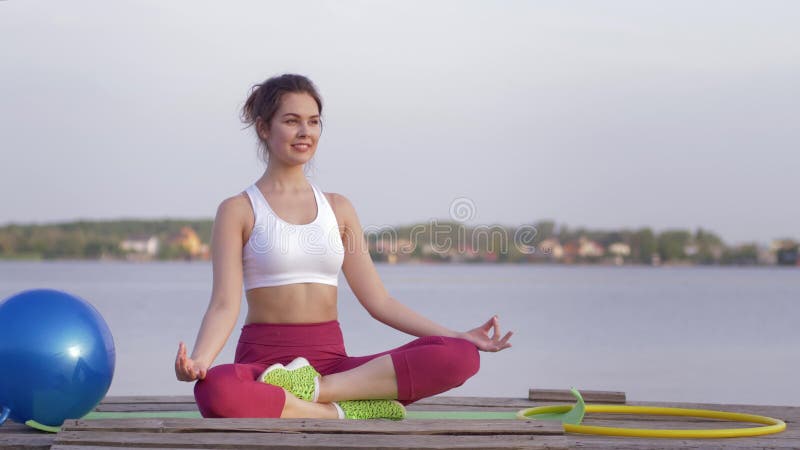 Le mode de vie de yoga, belle femme de yogi en position de lotus médite et aime les calmnes spirituels près de l'eau