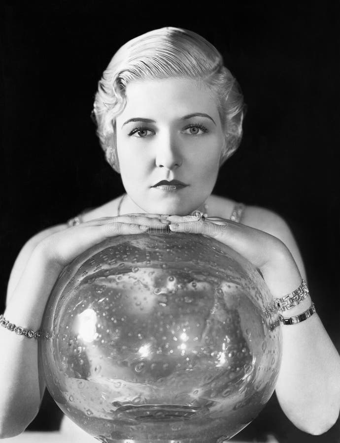 Le monde pourrait être son huître, mais cette jeune femme semble, se penchant sur sa boule de cristal (toutes les personnes repré photos libres de droits Le monde pourrait être son huître, mais cette jeune femme semble, se penchant sur sa boule de cristal (toutes les personnes repré photos libres de droits