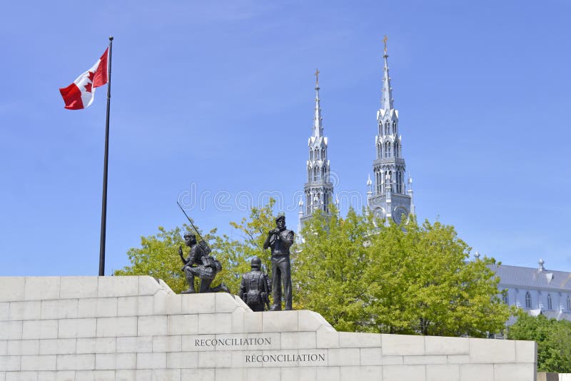 The reconciliation monument sits ironically in front of a grand church in Ottawa, Ontario, Canada. The reconciliation monument sits ironically in front of a grand church in Ottawa, Ontario, Canada