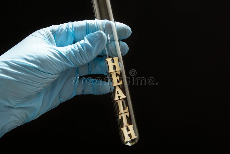Le mot “santé “dans un tube à essai en verre est aux mains d'un docteur dans les gants médicaux sur un fond noir photographie stock Le mot “santé “dans un tube à essai en verre est aux mains d'un docteur dans les gants médicaux sur un fond noir photographie stock