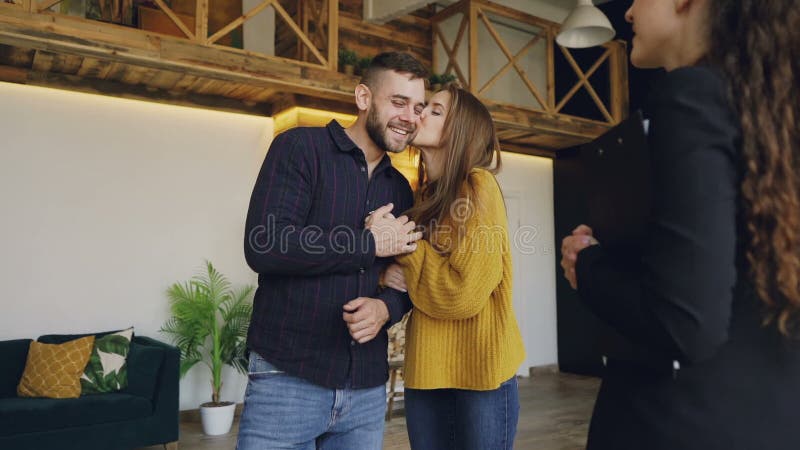 Le mouvement lent de l'agent immobilier amical donnant des clés à de beaux jeunes acheteurs de couples de nouvelle maison, les co banque de vidéos Le mouvement lent de l'agent immobilier amical donnant des clés à de beaux jeunes acheteurs de couples de nouvelle maison, les co banque de vidéos