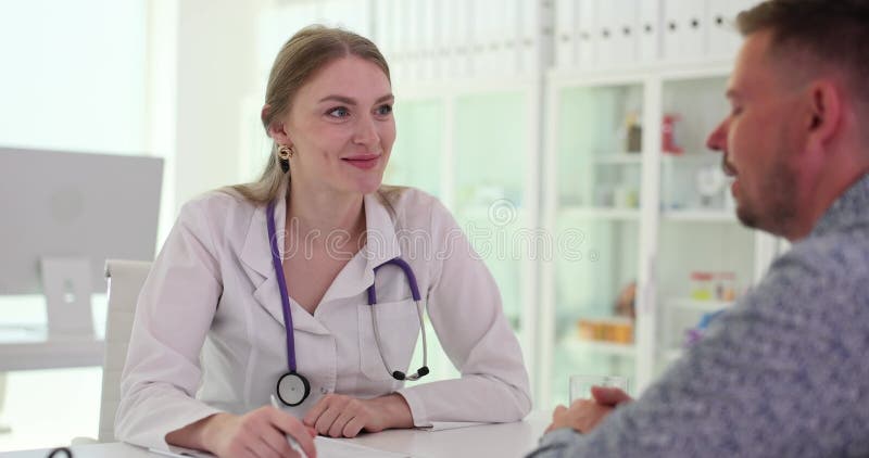 Le médecin communique avec le patient et enregistre les plaintes dans les antécédents médicaux banque de vidéos