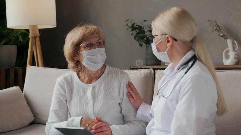 Le médecin communique avec le patient et touche son épaule banque de vidéos
