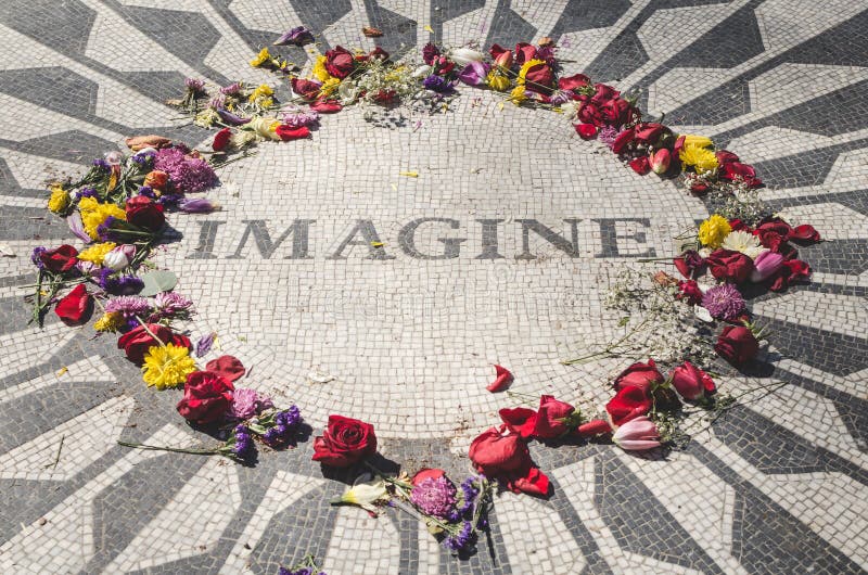 Landscape view of John Lennon`s memorial located at Central Park, New York surrounded by colorful flowers left by fans and tourists.  Imagine can be read on it. Landscape view of John Lennon`s memorial located at Central Park, New York surrounded by colorful flowers left by fans and tourists.  Imagine can be read on it.