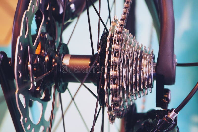 Le nuove parti della bicicletta, il cambio a catena, trasmissione, innesta la cassetta, fine del fondo su immagine stock Le nuove parti della bicicletta, il cambio a catena, trasmissione, innesta la cassetta, fine del fondo su immagine stock