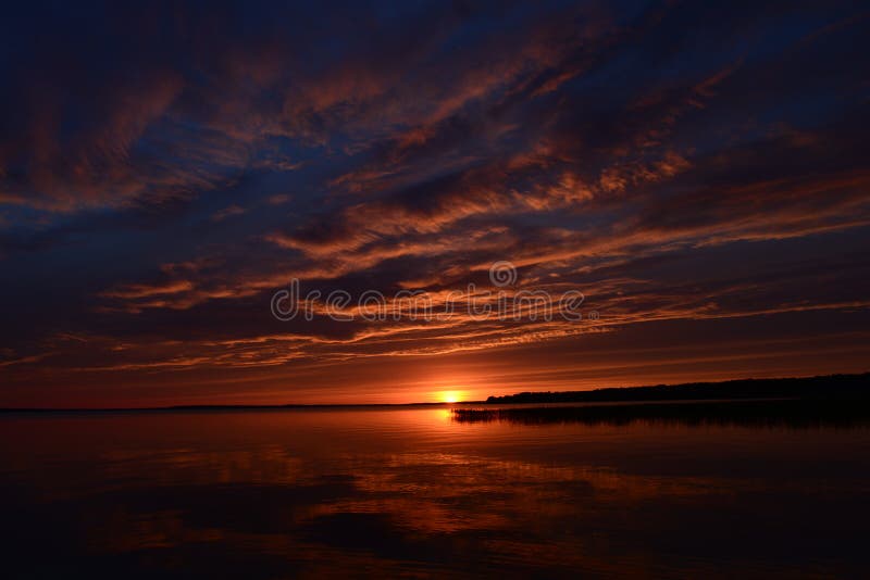 Le nuvole ed il tramonto hanno riflesso sull'acqua al crepuscolo immagine stock Le nuvole ed il tramonto hanno riflesso sull'acqua al crepuscolo immagine stock