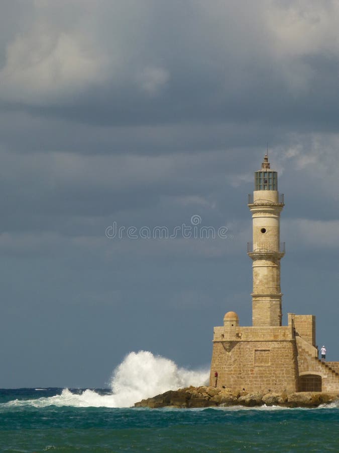 Le onde bianche con il molto spruzza l'arresto nel faro di Chania sotto un cielo grigio con le nuvole fotografia stock libera da diritti Le onde bianche con il molto spruzza l'arresto nel faro di Chania sotto un cielo grigio con le nuvole fotografia stock libera da diritti
