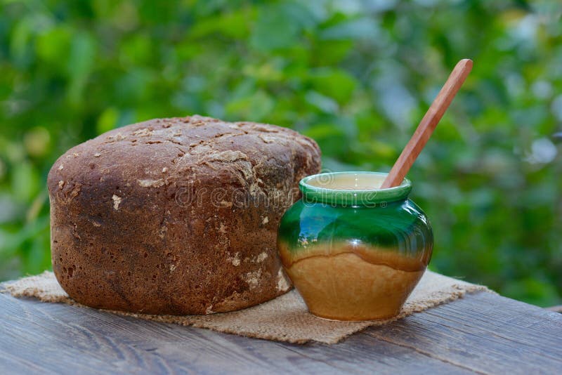 Le pain de seigle cuit au four et le vase en céramique photo stock Le pain de seigle cuit au four et le vase en céramique photo stock