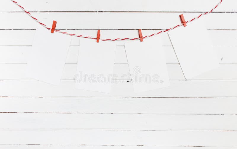 Le papier blanc ou la photo encadre accrocher sur la corde à linge rayée rouge Sur le fond en bois Descripteur pour votre texte photo libre de droits Le papier blanc ou la photo encadre accrocher sur la corde à linge rayée rouge Sur le fond en bois Descripteur pour votre texte photo libre de droits